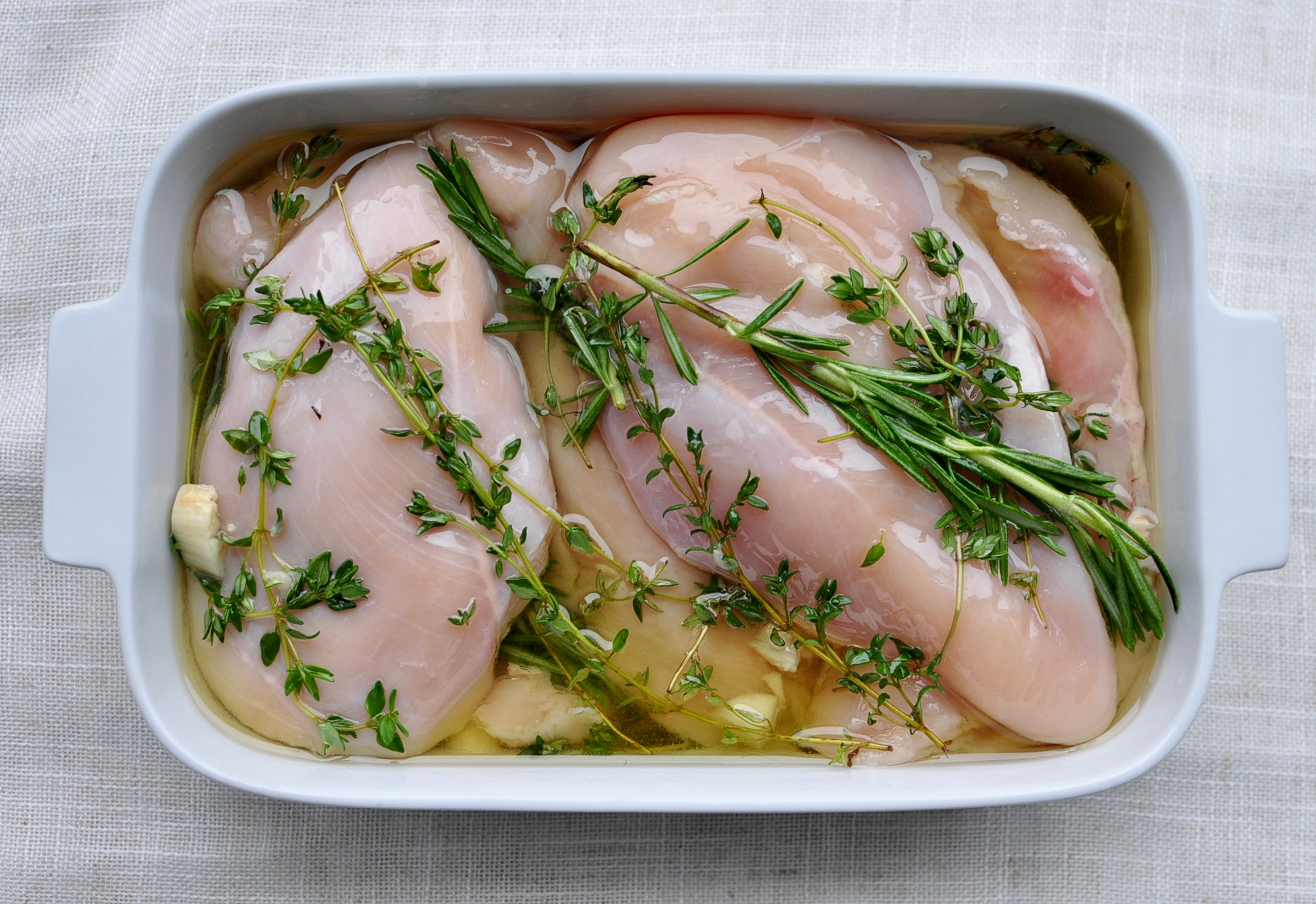 Chicken breasts marinating in infused olive oil