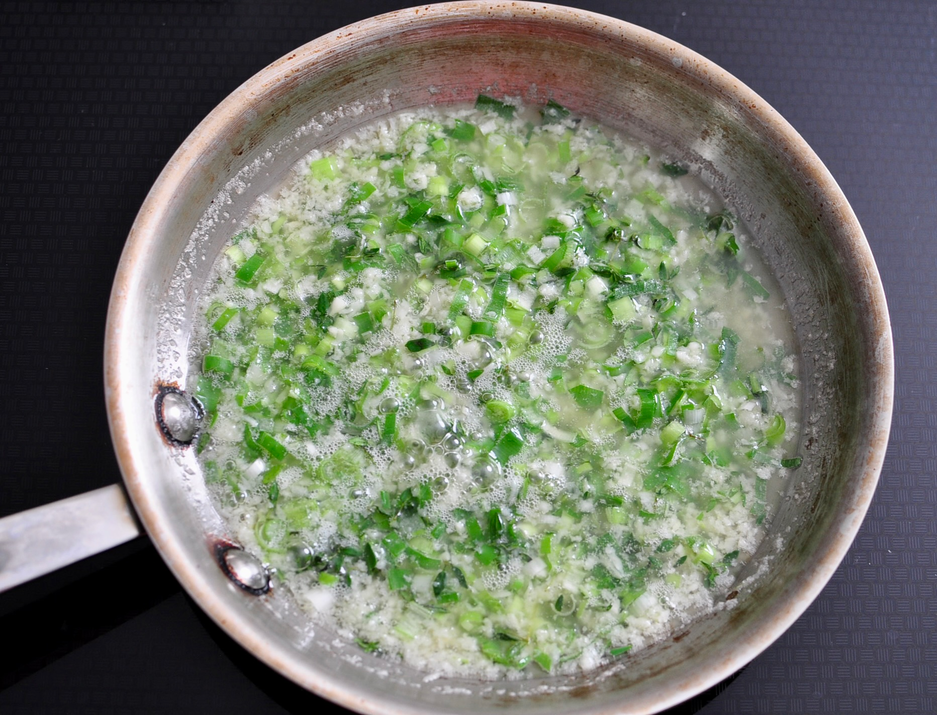 Gently cook garlic, scallions and thyme in beef tallow and butter..