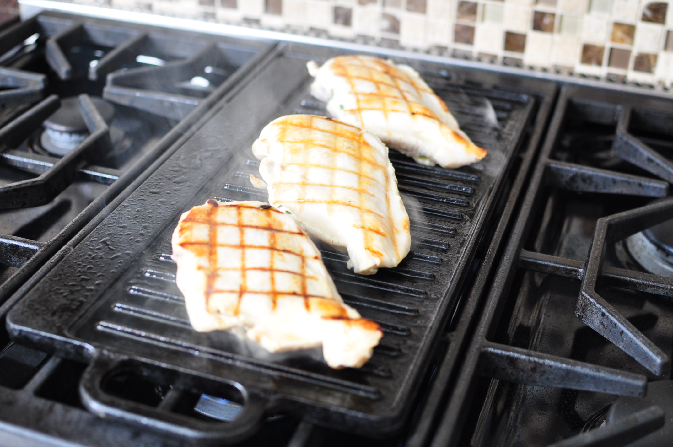 Chicken breasts on the grill with grill marks