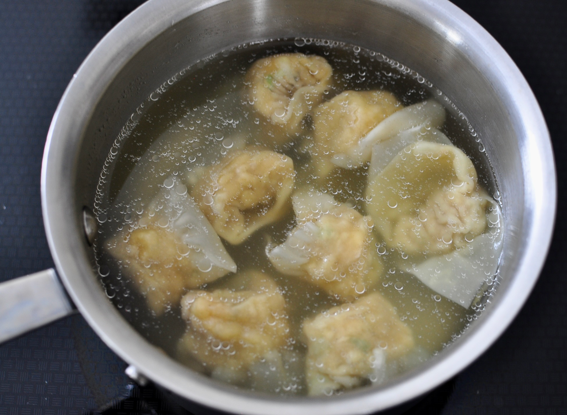 Wontons cooking in water.