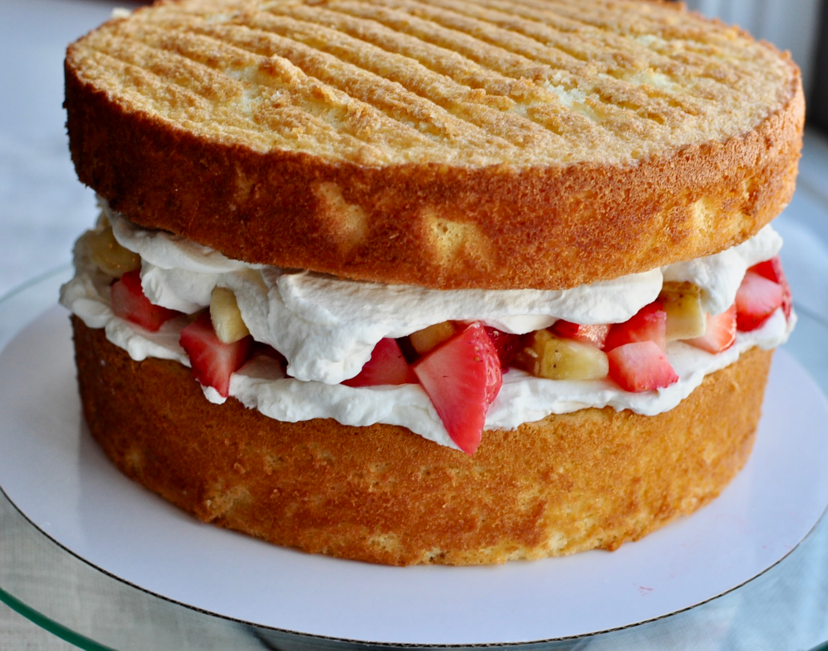 Naked layered c sponge cake with fruit and whipped cream