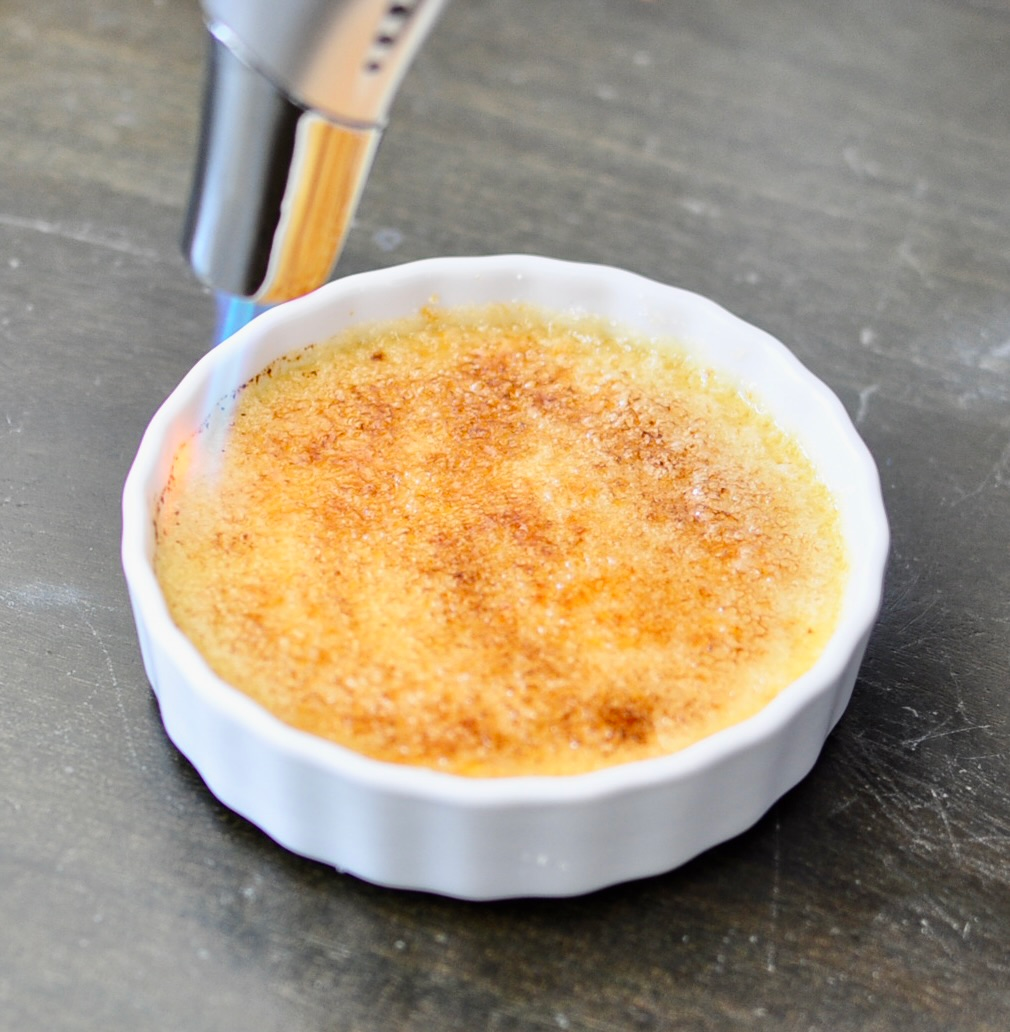 Kitchen torch caramelizing creme brulee