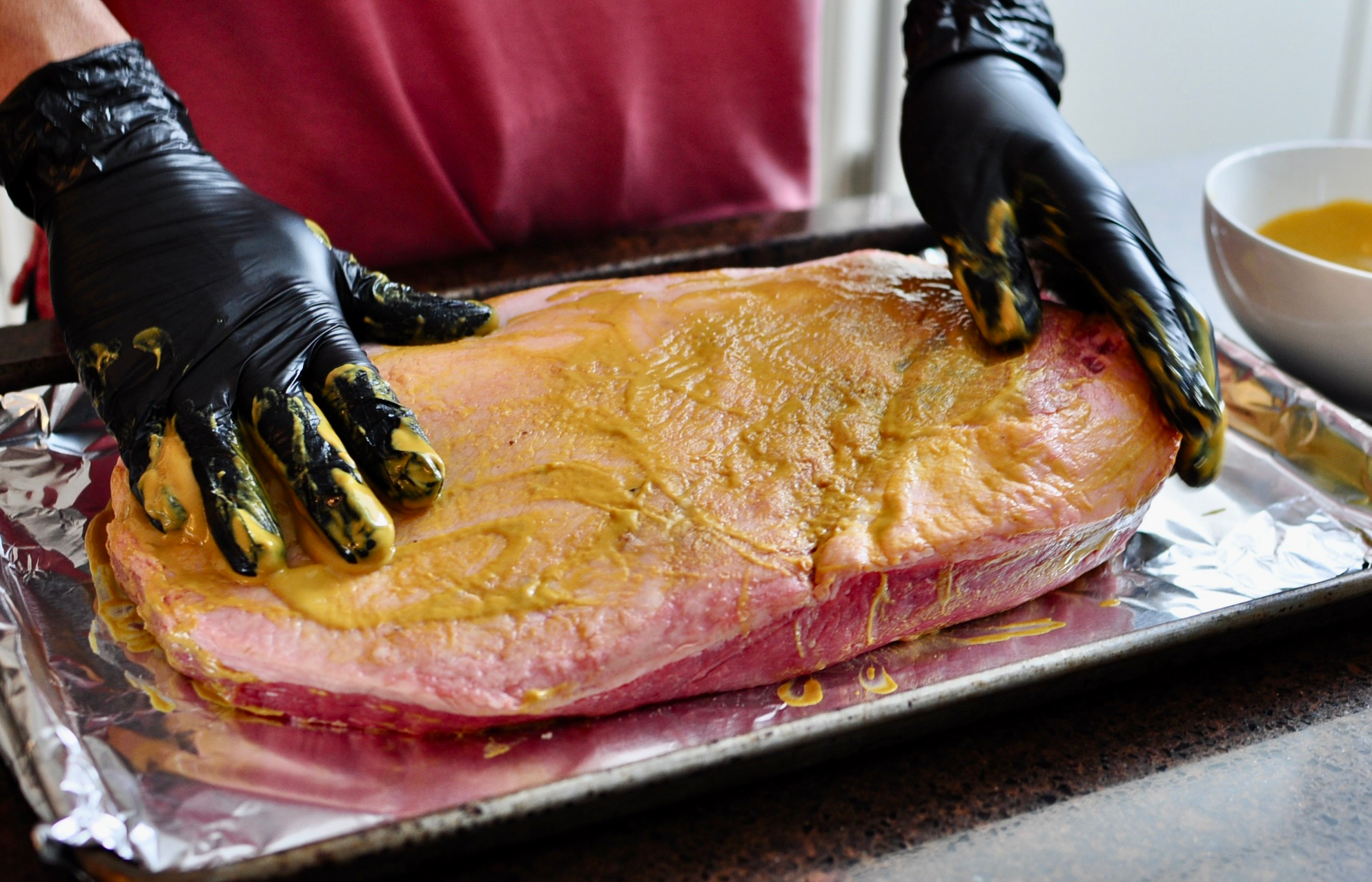 Rub mustard on brisket to act as a binder