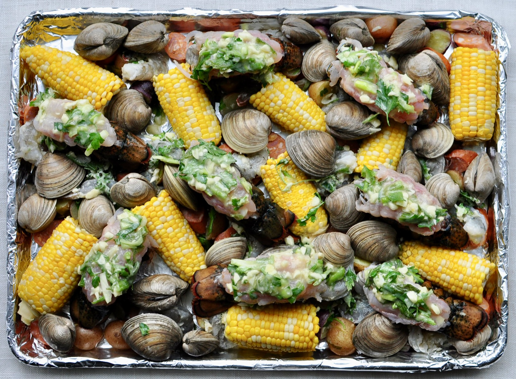 Sheet Pan Clam Bake with Corn, Potatoes, Andouille Sausage, Shrimp, Clams and Lobster Tails